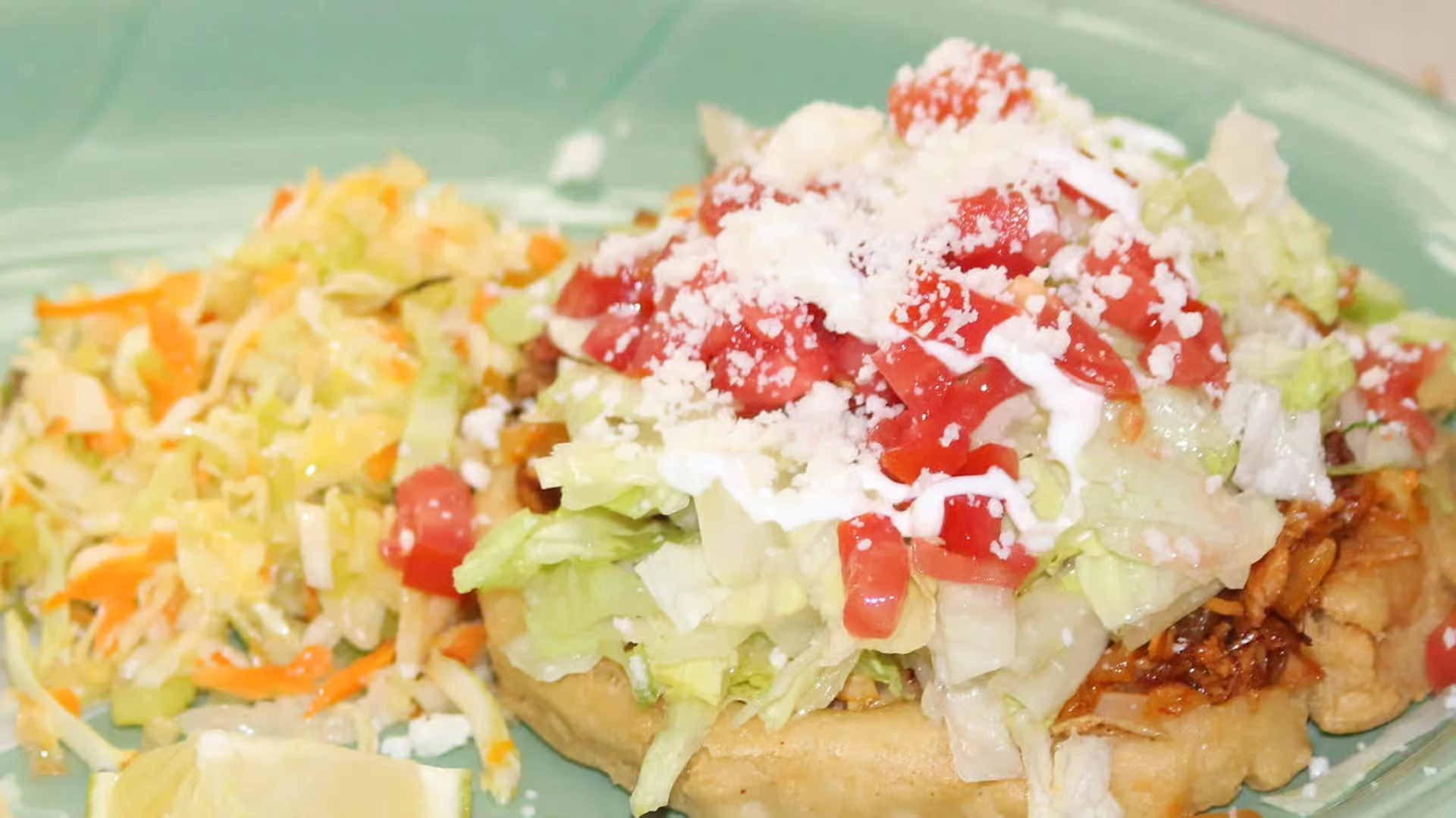 Homemade Sope - Thick handmade corn masa base topped with beans, meat, lettuce, cheese, and crema