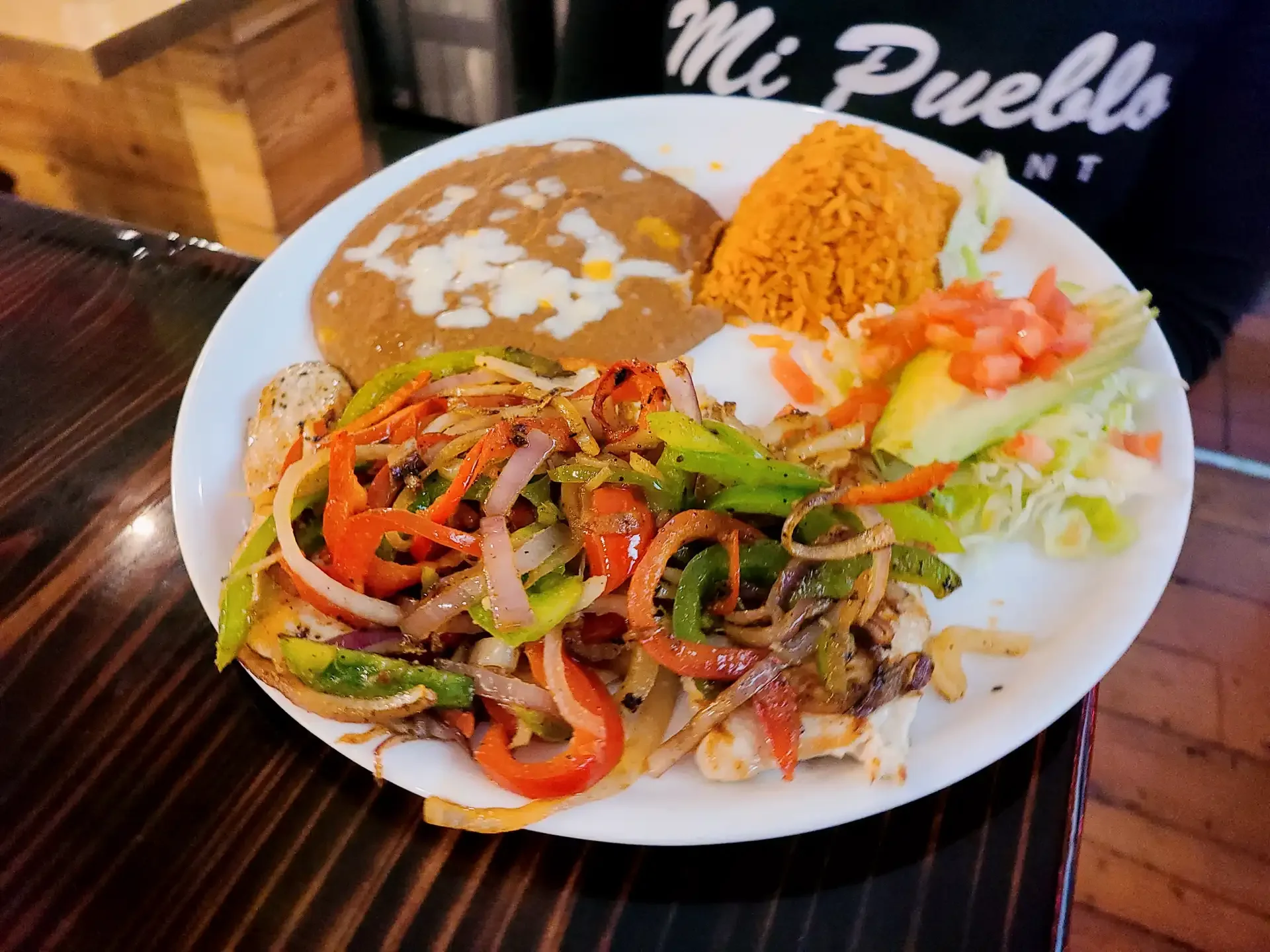 Pollo a la Plancha - Grilled chicken breast marinated in citrus and herbs, served with rice, beans, and fresh tortillas