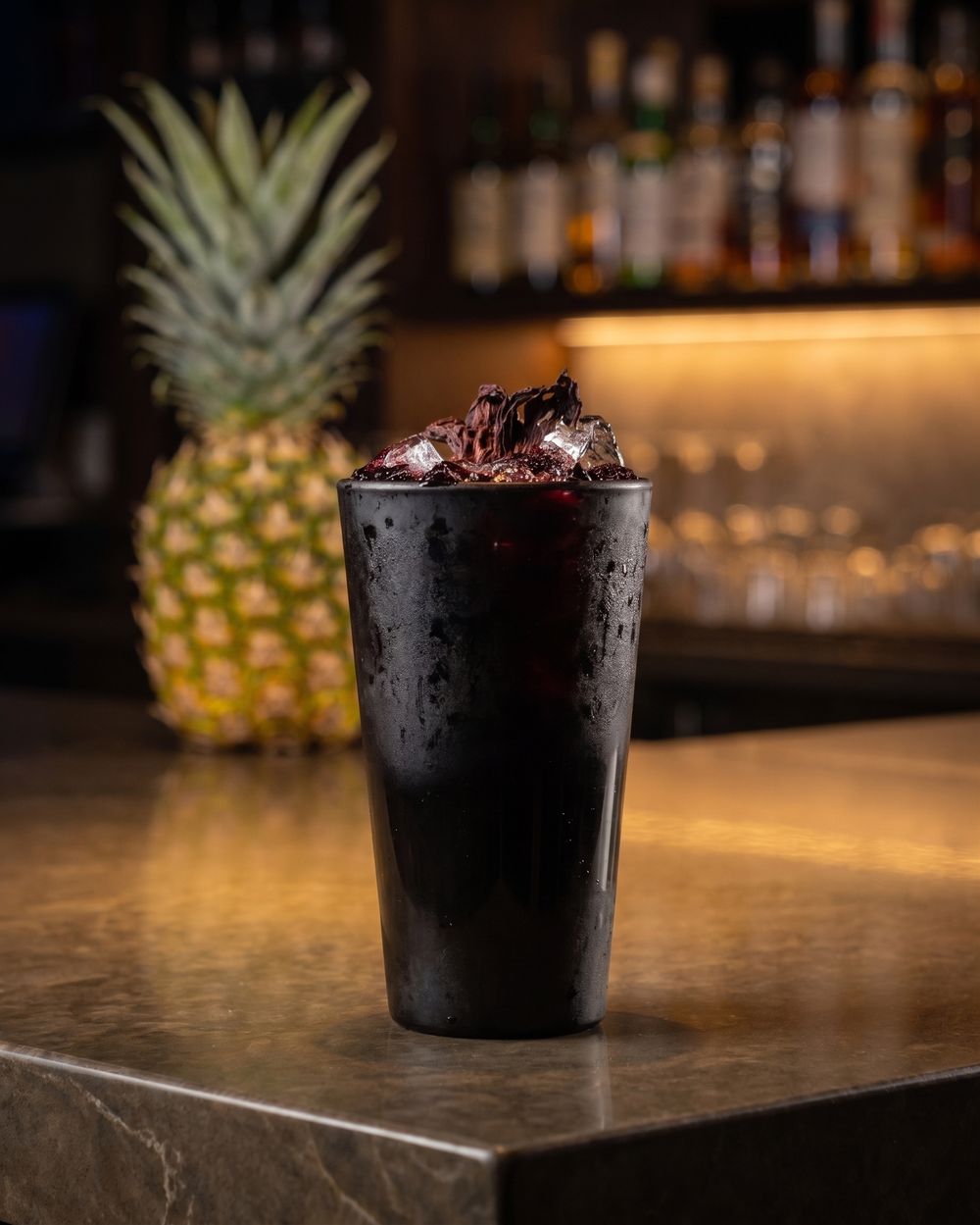 Agua de jamaica at the Mi Pueblo bar in downtown Santa Rosa, served over ice in a black cup with dried hibiscus flowers on top