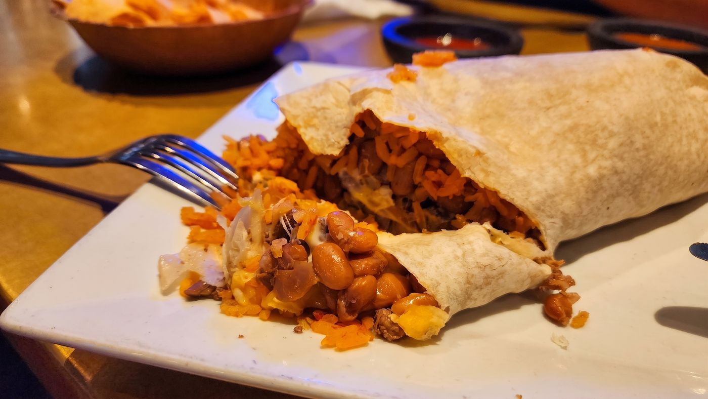 A burrito cut open at Mi Pueblo in downtown Santa Rosa, showing rice, beans, melted cheese and meat inside the flour tortilla