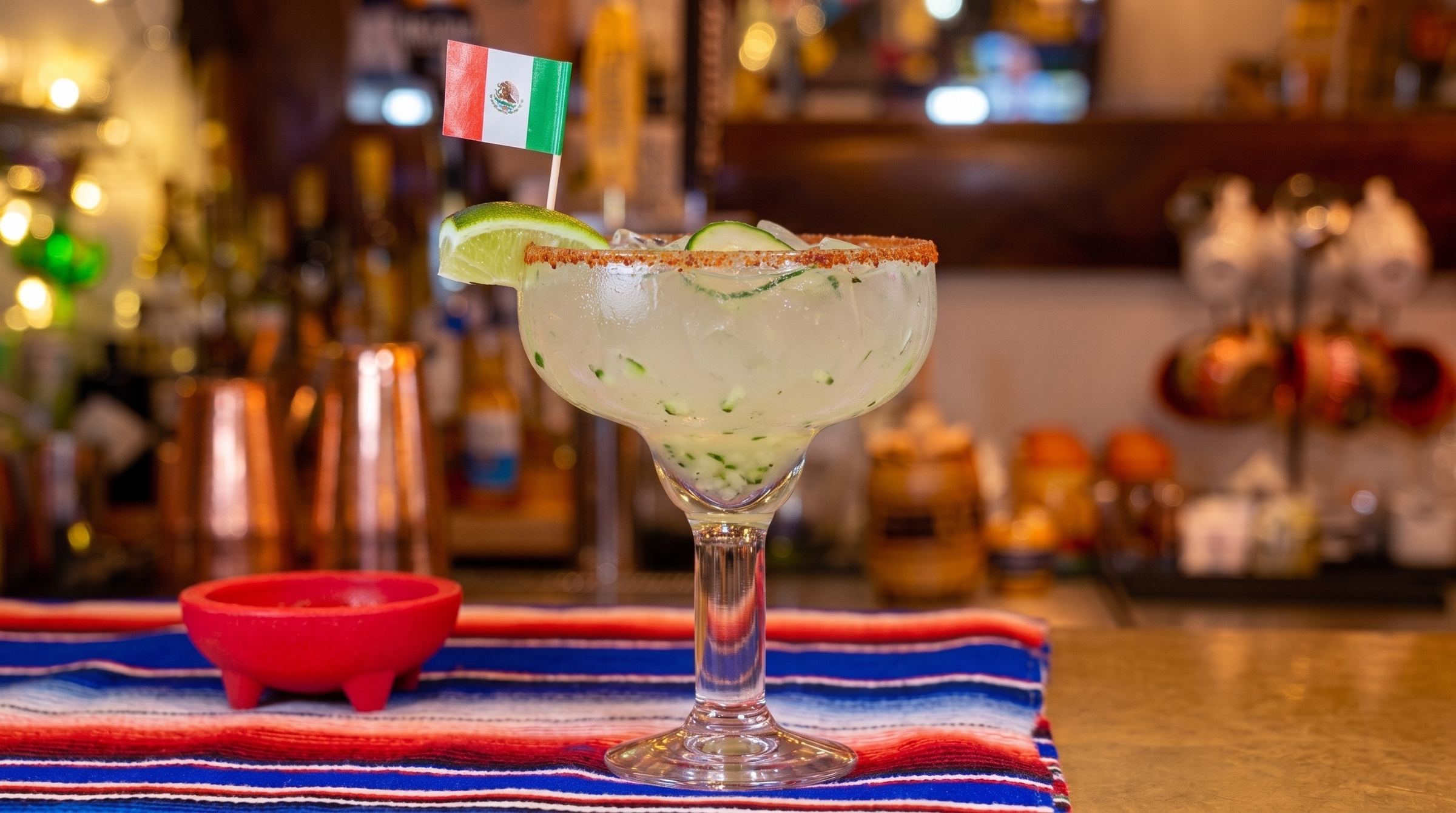 A cucumber margarita at the Mi Pueblo bar in downtown Santa Rosa, in a wide glass with a chili-salt rim, cucumber slices and lime