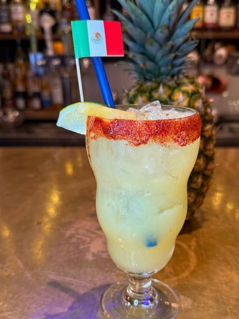 Una margarita de la casa con escarchado de chile y sal, limón y piña en la barra de Mi Pueblo en Santa Rosa